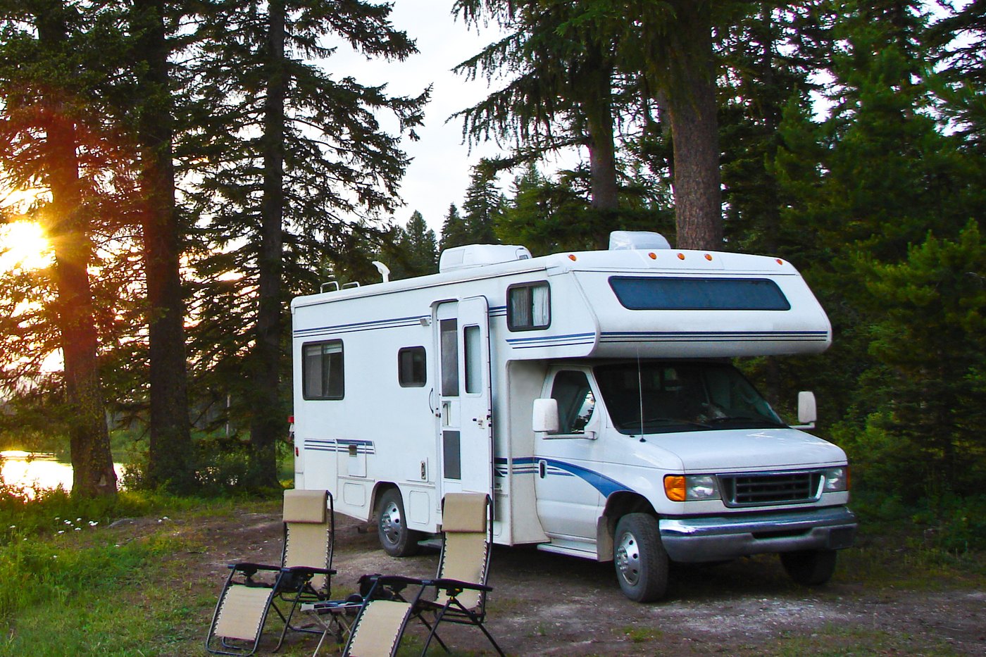 An RV camped beside a Maine lake at sunset