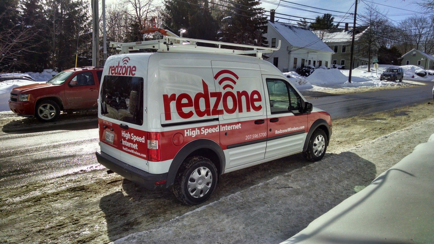A Redzone service van parked on a snowy Maine street